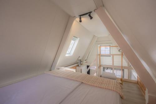 Cette chambre mansardée comprend un lit et une fenêtre. dans l'établissement Gasthuis Dokkum, à Dokkum