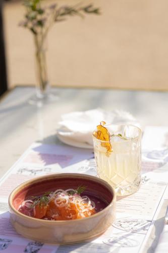 a bowl of soup sitting on a table with a glass at Grand Hotel National Luzern in Luzern
