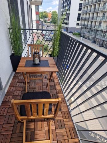a balcony with a wooden table and two chairs at Aurea apartment in Vilnius