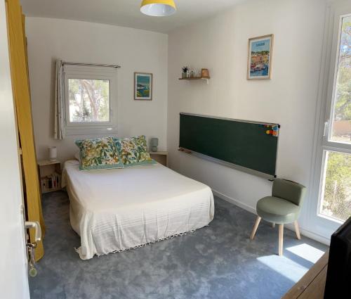 1 dormitorio pequeño con 1 cama y 1 silla en Chambre double cassis en Cassis