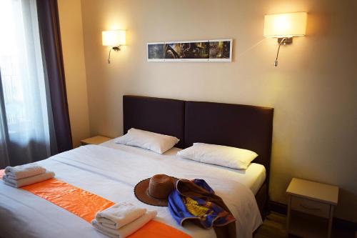 un letto con due asciugamani e un cappello sopra di Hotel restaurant le top du Roulier a Capendu