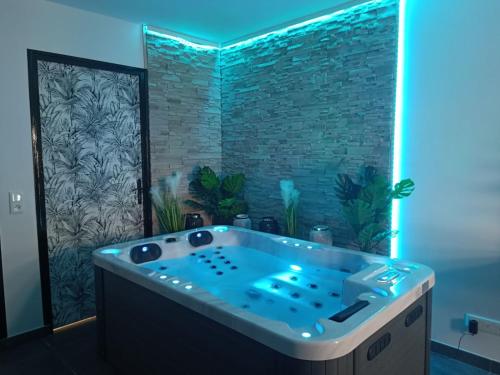 Évasion avec jacuzzi intérieur في Rosières-près-Troyes: حوض جاكوزي في حمام مع جدار من الطوب