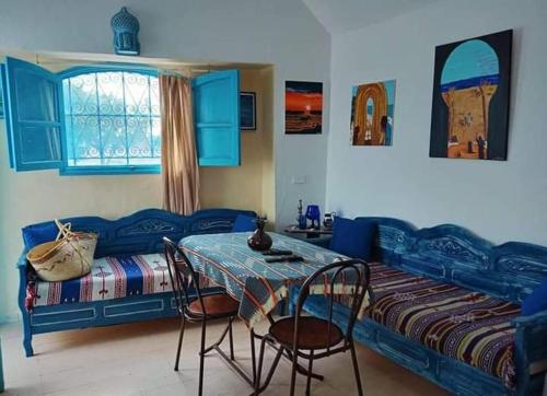 1 dormitorio con 1 cama, mesa y sillas en Bungalow de charme en Midoun