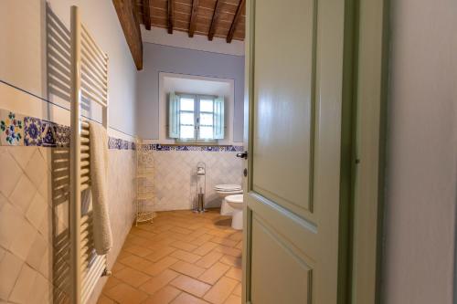 baño con aseo, ventana y puerta en Agriturismo I Savelli, en Castiglione dʼOrcia