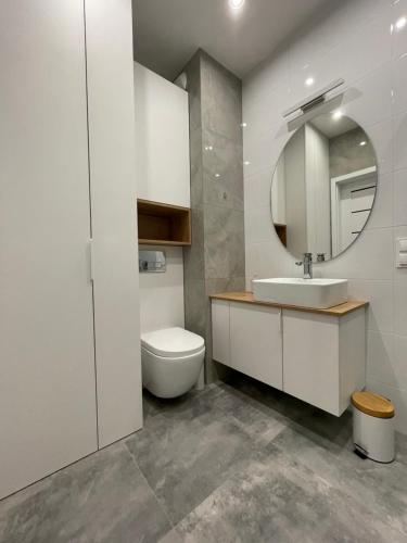 a bathroom with a toilet and a sink and a mirror at Apartament Pirat in Ostróda