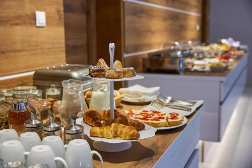 a breakfast buffet with pastries and croissants on a table at HOTEL Garni PATRIOT in Trnava