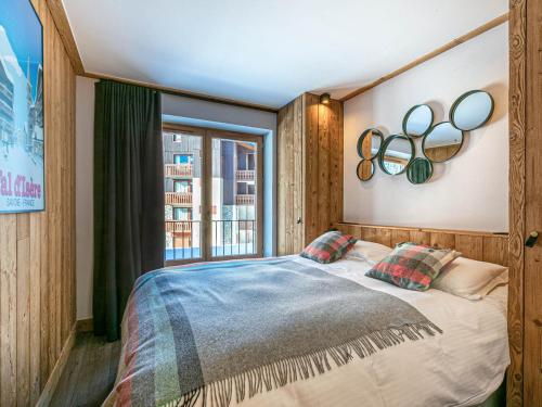 une chambre avec un grand lit et une fenêtre dans l'établissement Luxueux 4 pièces avec balcon, cheminée et services conciergerie à Val-d'Isère - FR-1-694-65, à Val dʼIsère