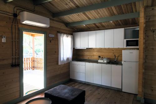 eine Küche mit weißen Schränken und einer Glasschiebetür in der Unterkunft Finca Florida in Benalup Casas Viejas