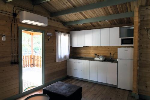 una cocina con armarios blancos y una puerta corredera de cristal en Finca Florida en Benalup Casas Viejas