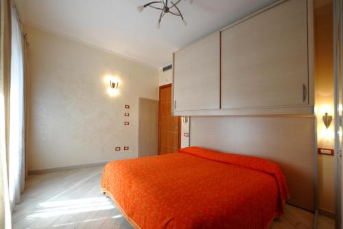 - une chambre avec un lit orange et une armoire blanche dans l'établissement MeFra Camere - Amalfi Coast, à Atrani