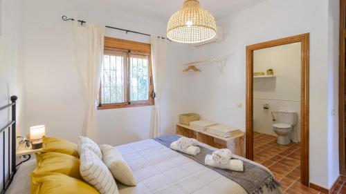 BorgeにあるCasa Los Limones El Borge by Ruralidaysのベッドルーム(ベッド1台、トイレ、鏡付)