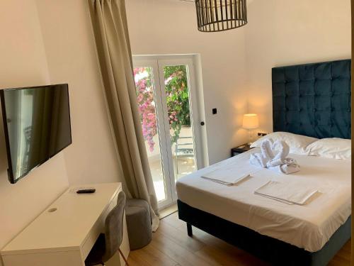 a bedroom with a bed and a table and a window at Gargamelo Pension in Poreč
