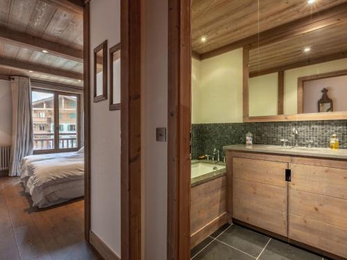 une salle de bain avec un lavabo, une baignoire et un lit dans l'établissement Luxueux 4 pièces avec alcove, superbe séjour, prestations haut de gamme, au cœur de Val-d'Isère - FR-1-694-167, à Val dʼIsère