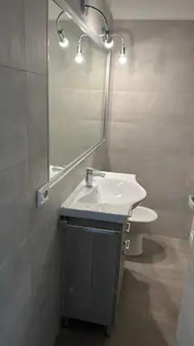 uma casa de banho com um lavatório e um espelho em Galvani 11 em Parma