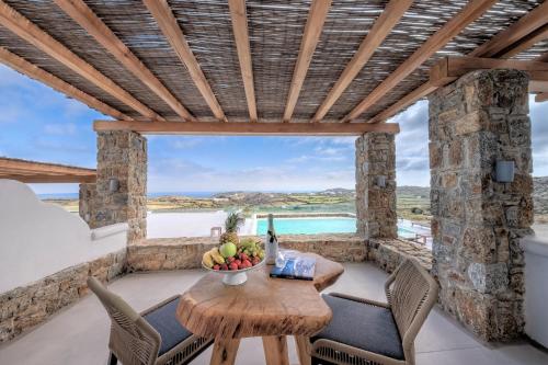 een patio met een tafel en stoelen en uitzicht op de oceaan bij Legendary Suites in Mykonos-stad
