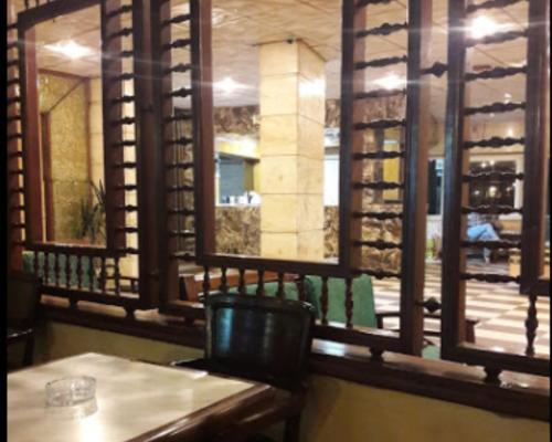 a room with a table and a window with wine bottles at Salvatore Rooms With Breakfast -Train Station in Mansoura