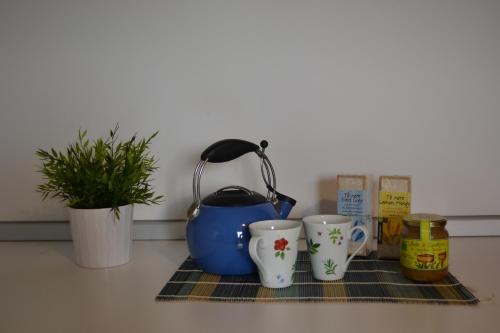 a tea kettle and two cups on a kitchen counter at A Pochi Passi in Venaria Reale