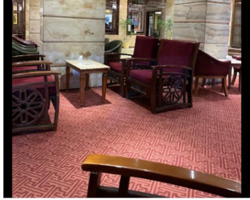 una habitación con sillas y mesas en una alfombra roja en Salvatore Rooms With Breakfast -Train Station en El Mansurá