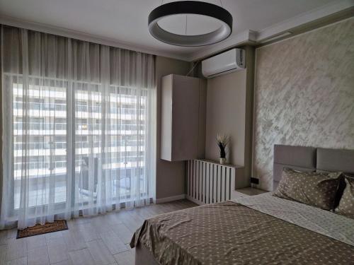 - une chambre avec un lit et une grande fenêtre dans l'établissement Studio Casa del Mar, Mamaia Nord, cu vedere la mare & lac, à Mamaia