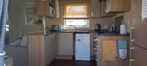 a small kitchen with a sink and a dishwasher at The Chill Out at Seton Sands in Port Seton