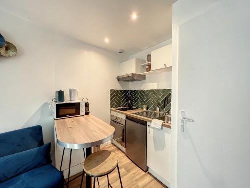 a small kitchen with a table and a blue couch at • CosyHouse By Janna • Terrasse - Wifi in Châtellerault