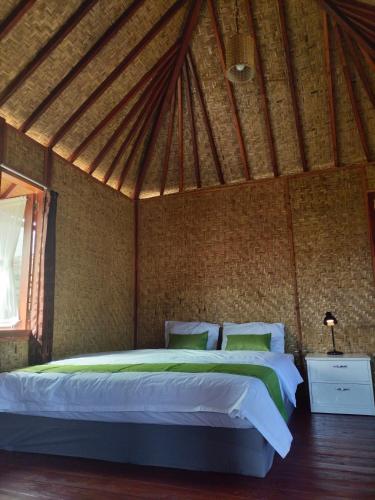 um quarto com uma cama grande numa tenda em Bogenvil Villa em Paloh