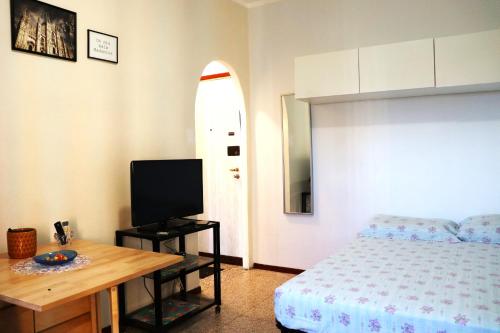 um quarto com uma cama, uma televisão e uma prancha de surf em * La Casa di Arti * 25 min dal Duomo em Milão