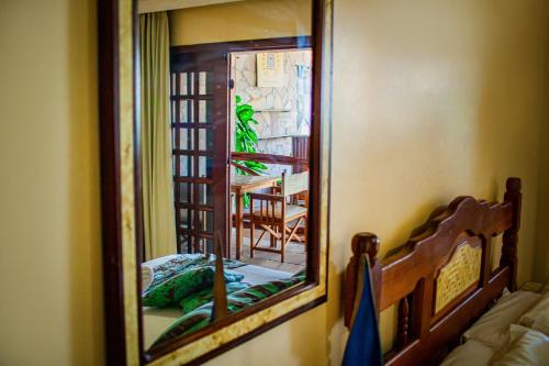 a mirror in a room with a bed and a table at Castelo Beach Hotel in Natal