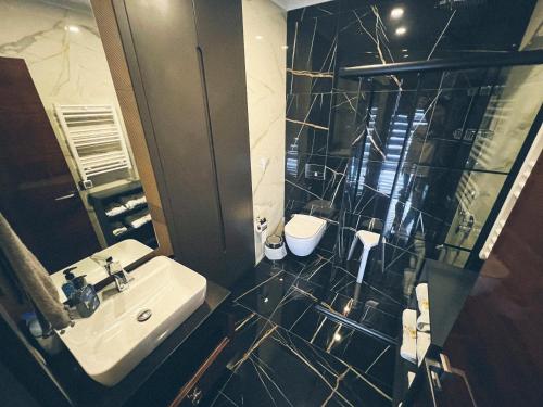uma casa de banho com um lavatório e um chuveiro em Luxus-Duplex Apartment, 12 und 13 Stock über Alanya, Whirlpool mit Meerblick, Bar, Bäder, Terrassen, Gym, private Tower Beach em Alanya