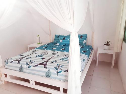 the village rua beach homestay في Rua: غرفة نوم مع سرير مع لحاف أزرق