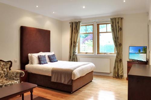 a bedroom with a bed and a television in it at The Atholl Palace in Pitlochry