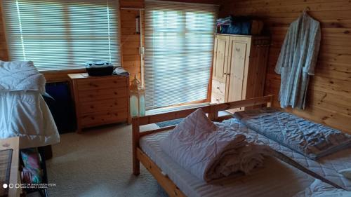 a bedroom with a bed and a dresser in a cabin at Landurlaub im Holzhaus in Ulrichshorst