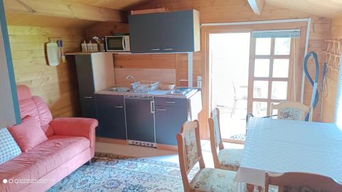 a kitchen and a living room with a couch and a table at Landurlaub im Holzhaus in Ulrichshorst