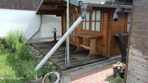 a gazebo with a bench on a deck at Landurlaub im Holzhaus in Ulrichshorst