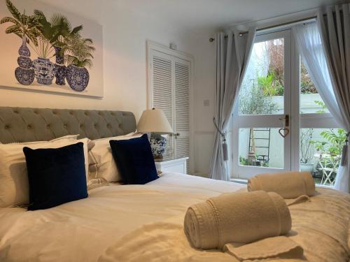 a bedroom with a large bed with blue pillows and a window at Olive Tree Apartment Hove in Brighton & Hove