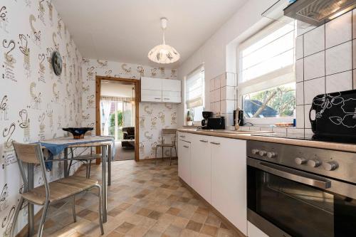 a kitchen with white cabinets and a table in it at Ferienwohnung Wenzlaff in Sassnitz