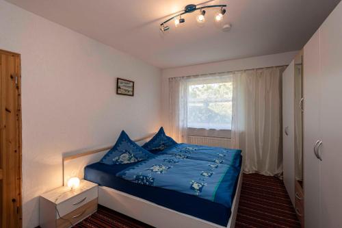 a bedroom with a blue bed and a window at Ferienwohnung Wenzlaff in Sassnitz