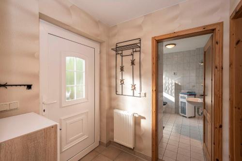 a bathroom with a door leading to a kitchen at Ferienwohnung Wenzlaff in Sassnitz