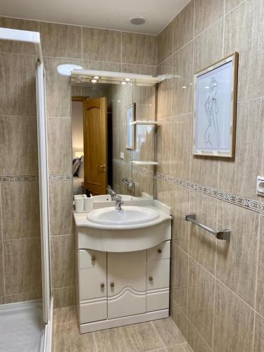 ein Bad mit einem Waschbecken und einem Spiegel in der Unterkunft Andainas Apartamentos Turísticos G in O Milladoiro