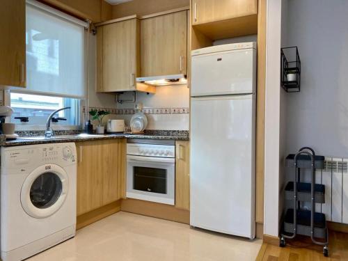 eine Küche mit einem weißen Kühlschrank und einem Geschirrspüler in der Unterkunft Andainas Apartamentos Turísticos G in O Milladoiro