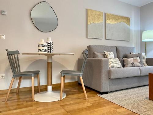 a living room with a couch and a table and chairs at Andainas G in Milladoiro