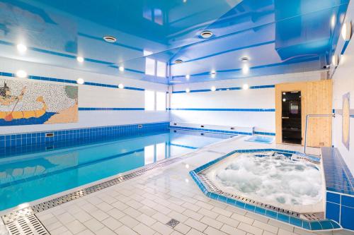 een zwembad met een hot tub in het midden bij Hotel Reśliński in Grodzisk Wielkopolski