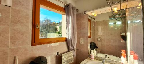 La salle de bains est pourvue d'un lavabo, d'une baignoire et d'une fenêtre. dans l'établissement Maison conviviale avec jacuzzi à Le Bar-sur-Loup, à Le Bar-sur-Loup