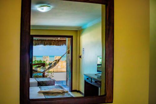a mirror in a room with a view of a balcony at Castelo Beach Hotel in Natal