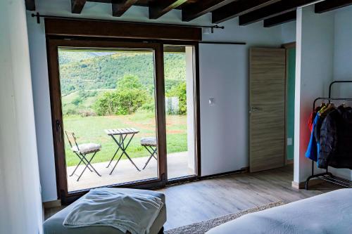 a bedroom with a large sliding glass door with a table and chairs at El Mirador de las Cuencas in Abiada