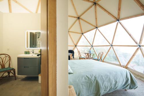 a bedroom in a yurt with a bed and a desk at Dôme avec vue sur Loire proche de Chambord in Saint-Dyé-sur-Loire