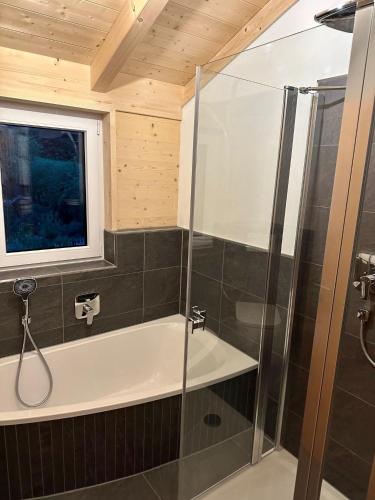 a bathroom with a shower and a bath tub at Ferienhaus Bergstätter Sonne in Immenstadt im Allgäu