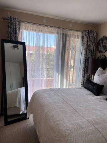 a bedroom with a bed and a large window at Iyana Place in Midrand