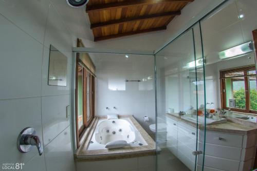 uma casa de banho com banheira e chuveiro em Pousada Bangalôs do Rosa-Praia do Rosa na Praia do Rosa