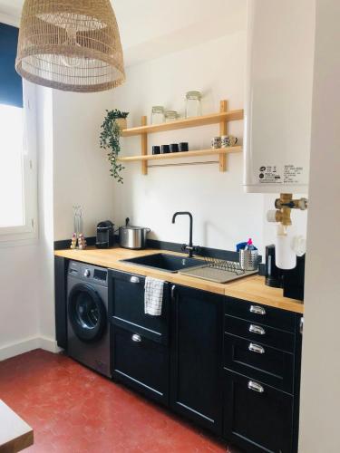 une cuisine avec un évier et une machine à laver dans l'établissement Le repère des pêcheurs, à Marseille